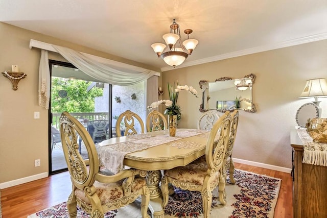 dining area featuring ornamental molding, hardwood / wood-style floors, and an inviting chandelier