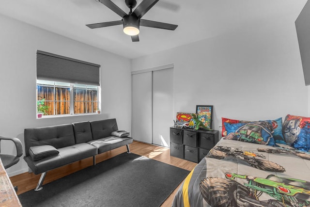 bedroom with ceiling fan, light hardwood / wood-style floors, and a closet