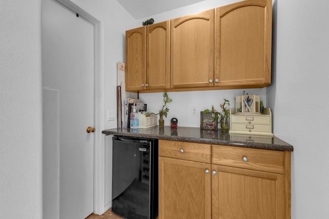 kitchen with wine cooler and dark stone countertops