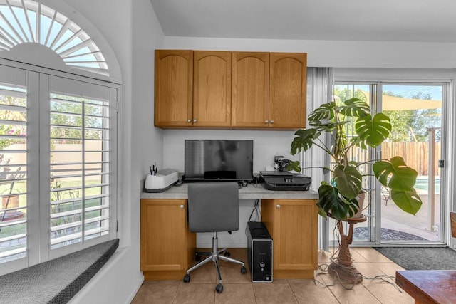 tiled office space featuring plenty of natural light and built in desk