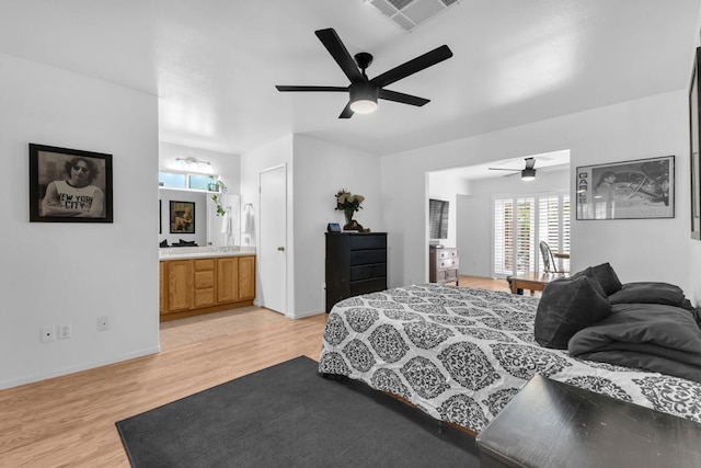 bedroom featuring connected bathroom, light hardwood / wood-style flooring, and ceiling fan