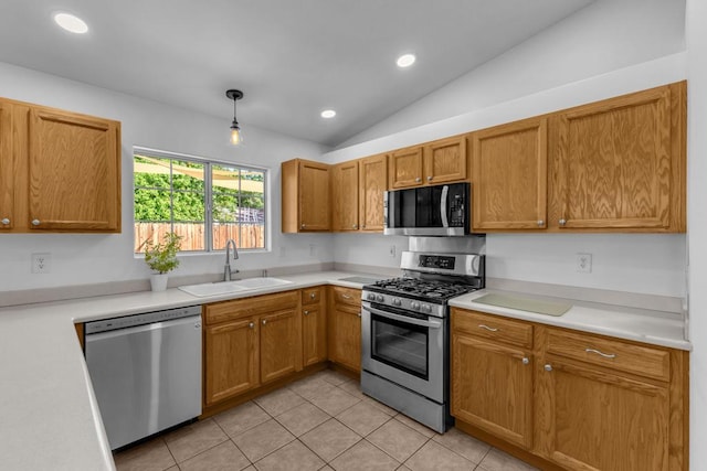 kitchen featuring pendant lighting, sink, appliances with stainless steel finishes, light tile patterned flooring, and vaulted ceiling