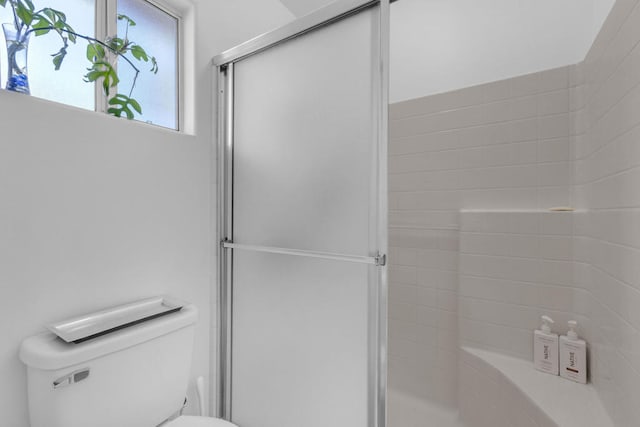 bathroom featuring an enclosed shower and toilet