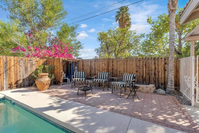 view of patio / terrace with a fenced in pool and an outdoor fire pit