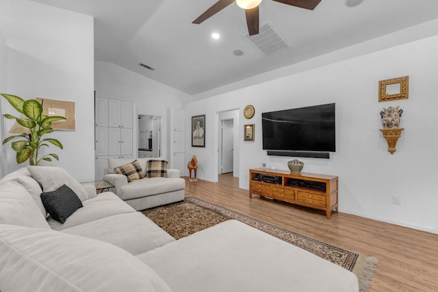 living room with ceiling fan, vaulted ceiling, and light wood-type flooring