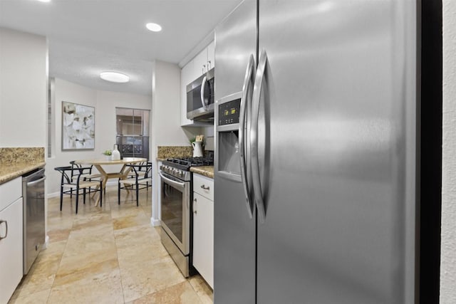 kitchen featuring stone counters, appliances with stainless steel finishes, and white cabinets