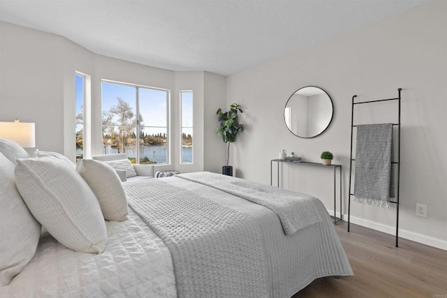 bedroom featuring a water view and wood-type flooring