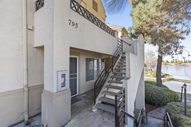 doorway to property with a water view and stucco siding