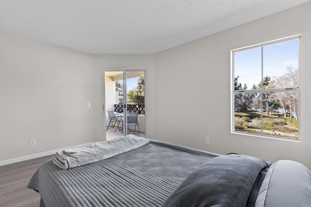 bedroom with baseboards and wood finished floors