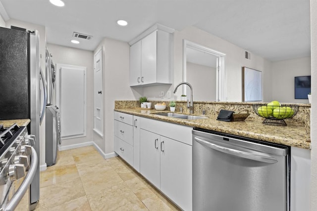 kitchen featuring stainless steel appliances, visible vents, white cabinets, a sink, and light stone countertops