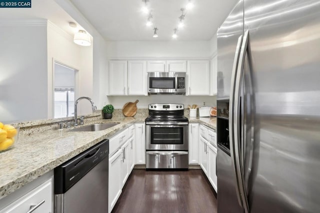 kitchen featuring light stone counters, stainless steel appliances, sink, and white cabinets