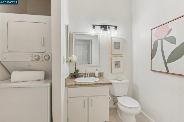 bathroom featuring tile patterned flooring, vanity, stacked washer and clothes dryer, and toilet