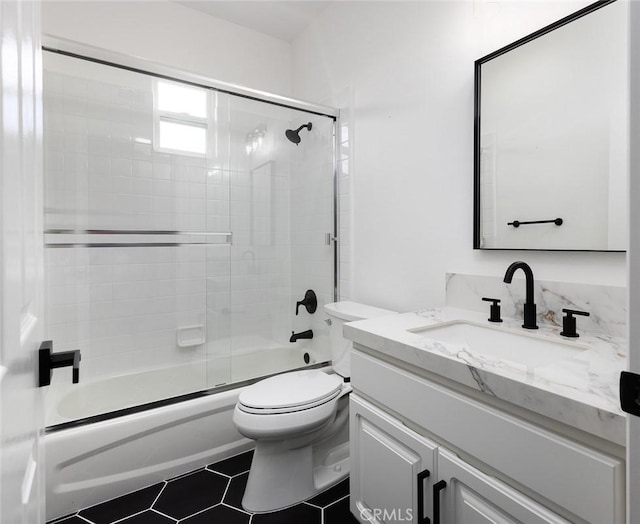 full bathroom with toilet, tile patterned flooring, combined bath / shower with glass door, and vanity