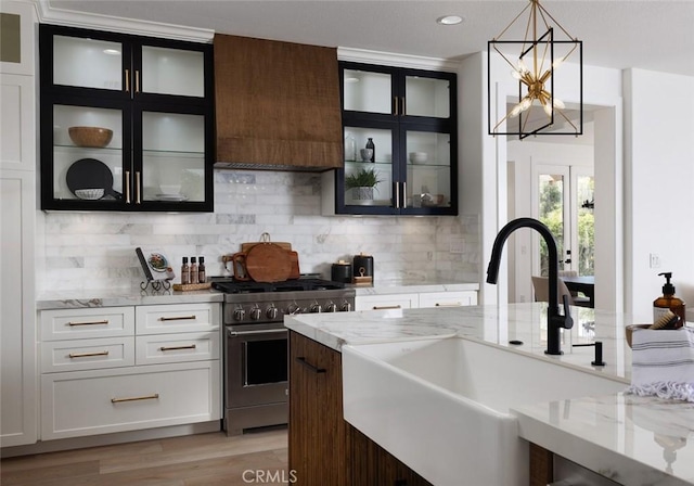 kitchen with dark brown cabinets, sink, high end stainless steel range, and white cabinets