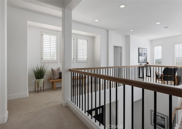 hallway with plenty of natural light and light colored carpet