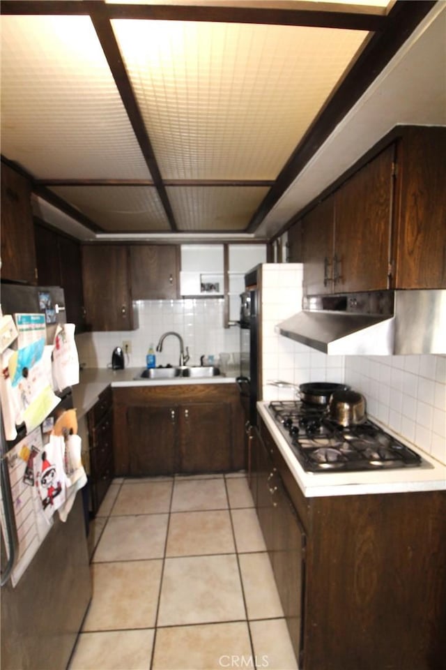 kitchen with stainless steel appliances, light countertops, a sink, and backsplash