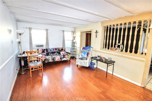 living room featuring hardwood / wood-style floors and beamed ceiling