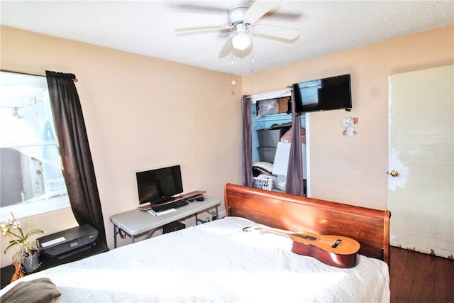 bedroom featuring a ceiling fan, a textured ceiling, and wood finished floors