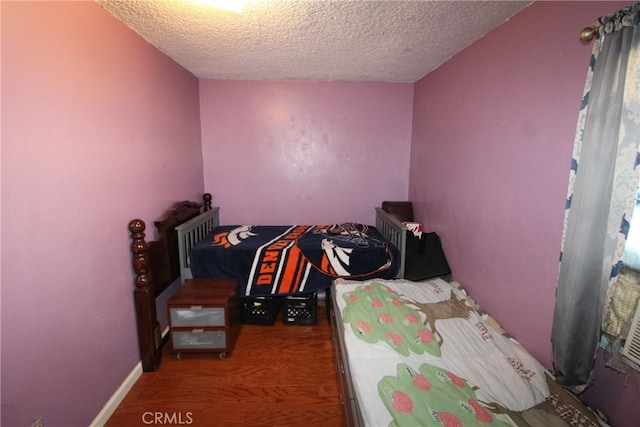 bedroom with baseboards and a textured ceiling