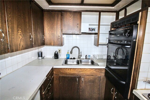 kitchen featuring sink, dark brown cabinetry, and decorative backsplash