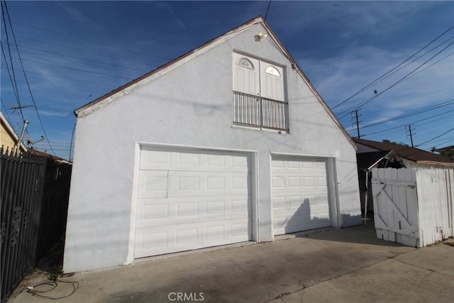 detached garage featuring fence