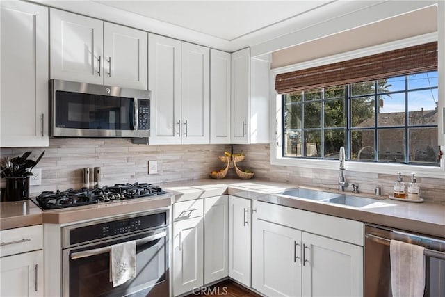 13056 Burns Ln, Redlands, CA 92373 - kitchen with stainless steel appliances, a sink, white cabinetry, light countertops, and backsplash