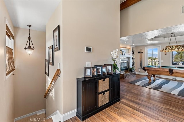 interior space with hardwood / wood-style flooring, a tile fireplace, and pool table