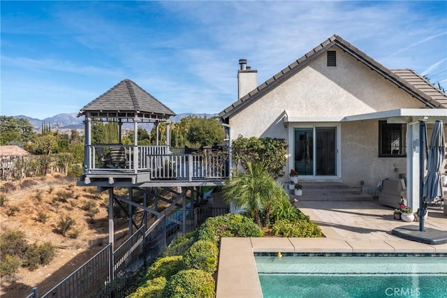 13056 Burns Ln, Redlands, CA 92373 - rear view of house featuring a gazebo, a chimney, stucco siding, a patio area, and a mountain view
