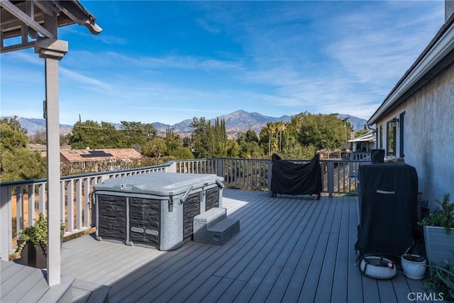 wooden terrace with a hot tub and a mountain view