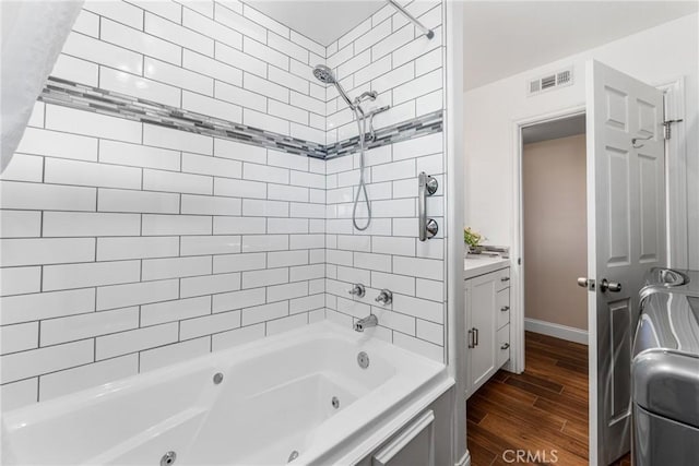 bathroom featuring tiled shower / bath and vanity