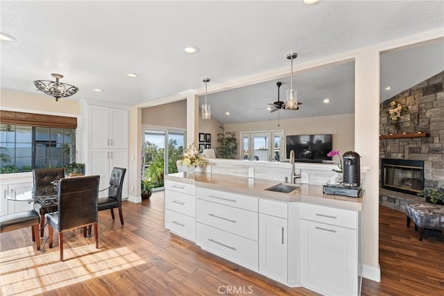 kitchen featuring white cabinetry, lofted ceiling, sink, and pendant lighting