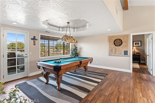 rec room with hardwood / wood-style flooring, pool table, a raised ceiling, and a wealth of natural light