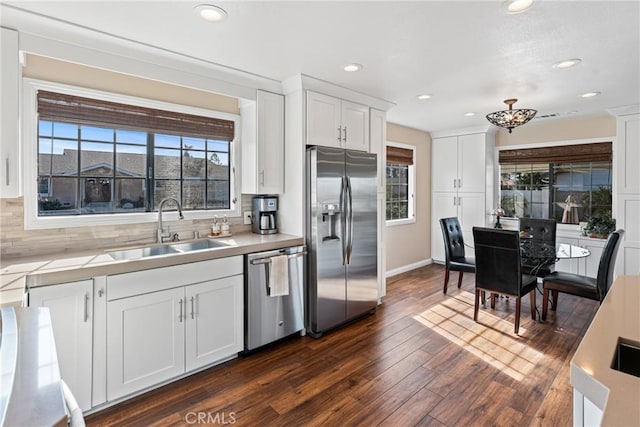 kitchen featuring tasteful backsplash, sink, white cabinets, and appliances with stainless steel finishes