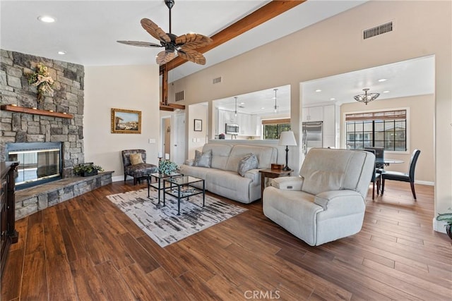 living room featuring ceiling fan, wood-type flooring, a stone fireplace, and vaulted ceiling