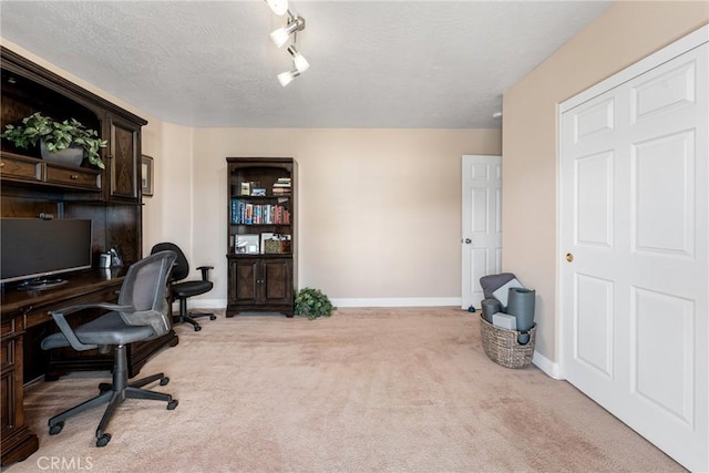 home office featuring track lighting, carpet flooring, and a textured ceiling