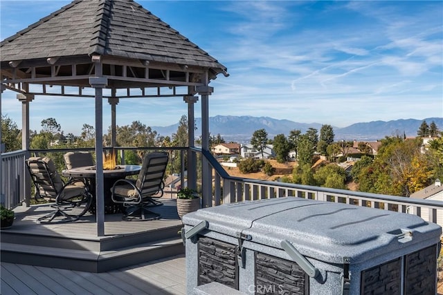 wooden deck with a gazebo, a hot tub, and a mountain view