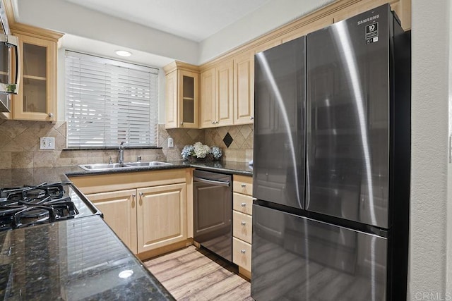 kitchen with sink, backsplash, stainless steel appliances, and light hardwood / wood-style floors