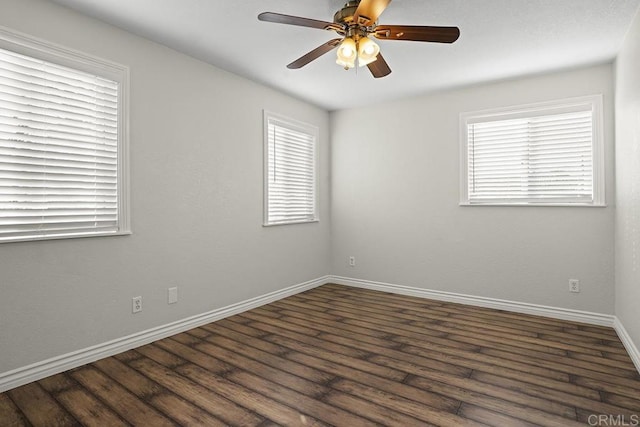 empty room with ceiling fan and dark hardwood / wood-style floors