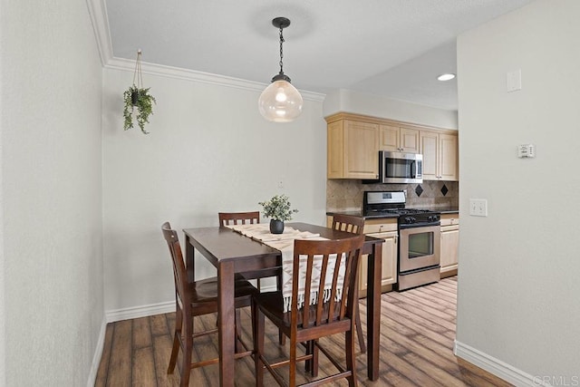 dining area with ornamental molding and dark hardwood / wood-style flooring