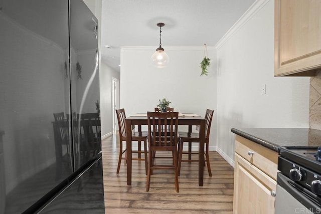 dining room with ornamental molding and hardwood / wood-style floors