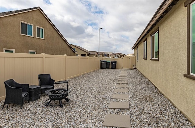 view of yard featuring an outdoor fire pit and a patio