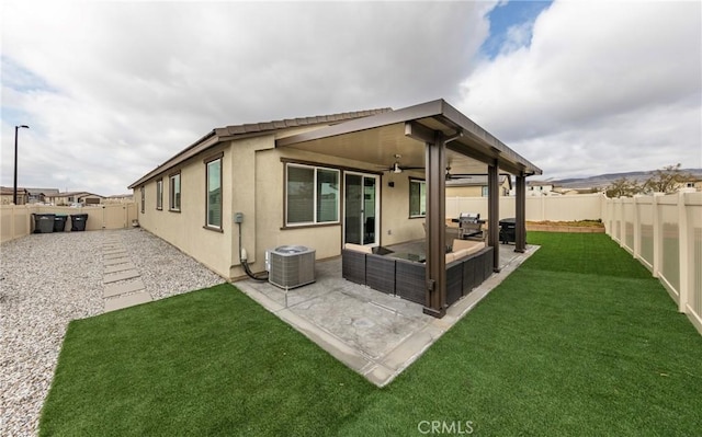 rear view of house featuring a yard, central air condition unit, ceiling fan, and a patio area