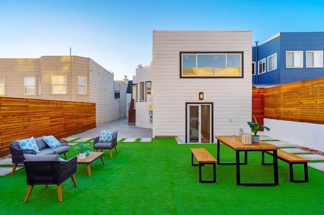 rear view of property with an outdoor living space and a yard