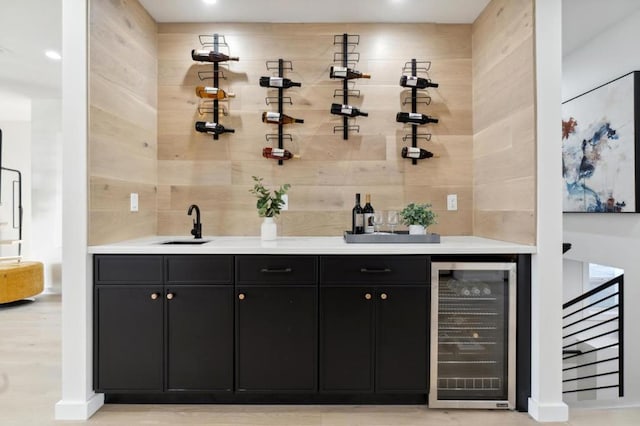 bar featuring tasteful backsplash, sink, tile walls, and beverage cooler