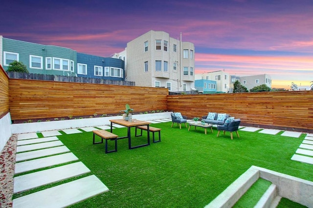 yard at dusk featuring an outdoor hangout area