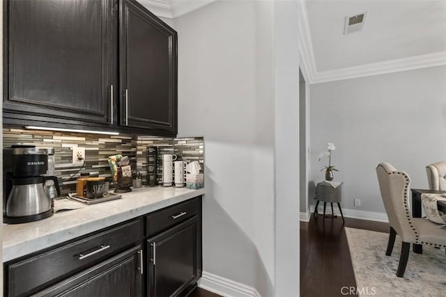 bar featuring tasteful backsplash, hardwood / wood-style flooring, and ornamental molding