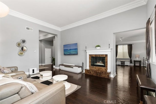 living room featuring dark hardwood / wood-style flooring, a fireplace, and ornamental molding