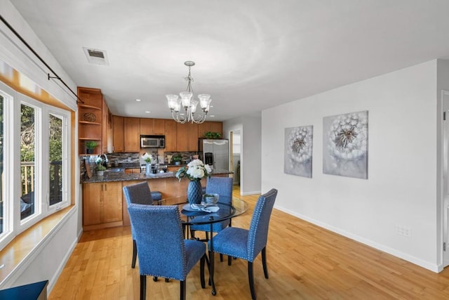 dining space featuring a chandelier and light wood-type flooring