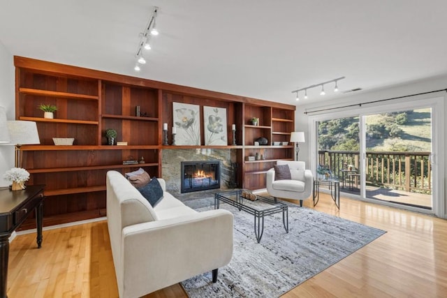 living room featuring built in features and light hardwood / wood-style flooring