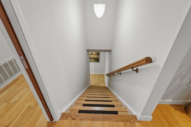 staircase with hardwood / wood-style flooring